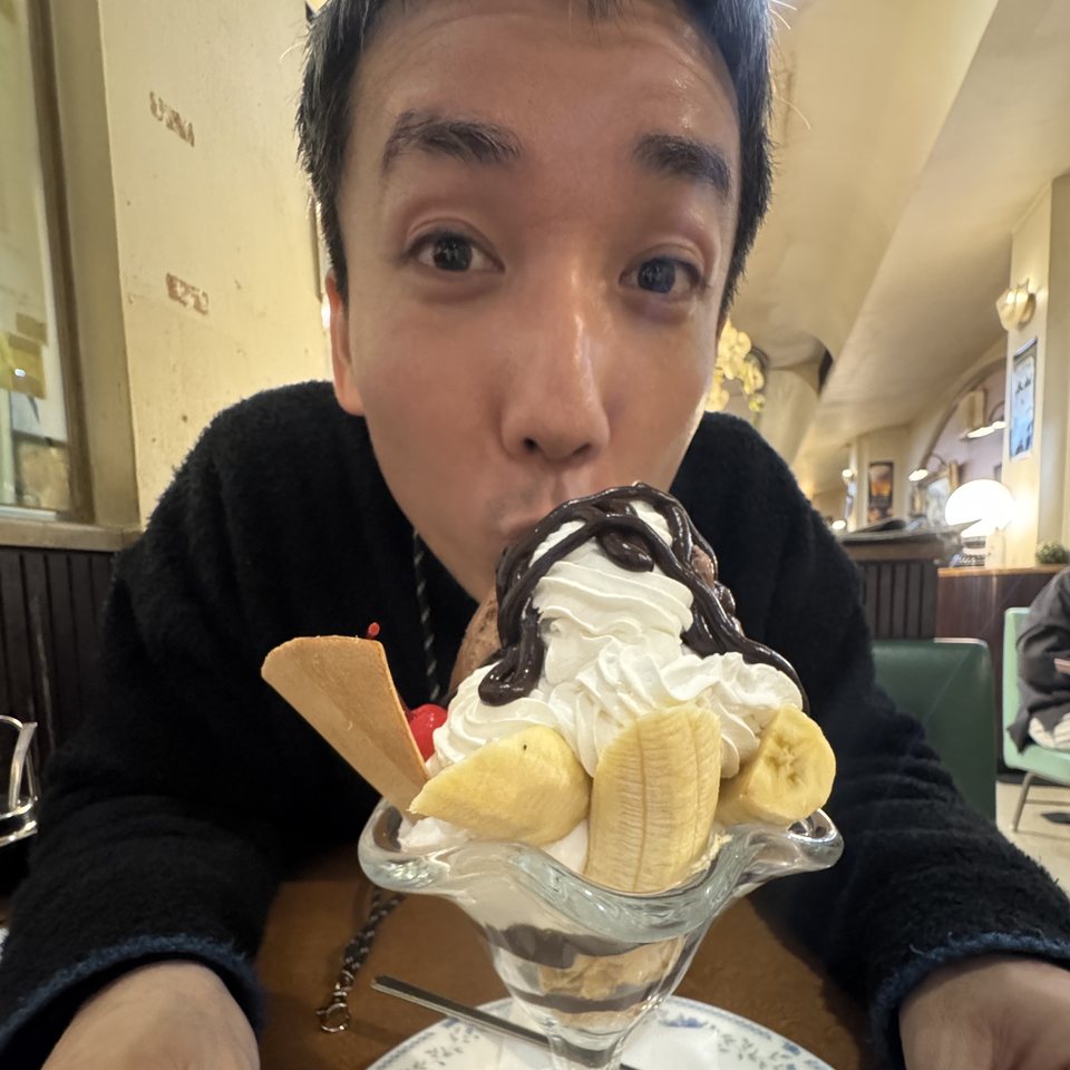 チョコレートパフェを前に、口をすぼめてこちらを見る石村侑二